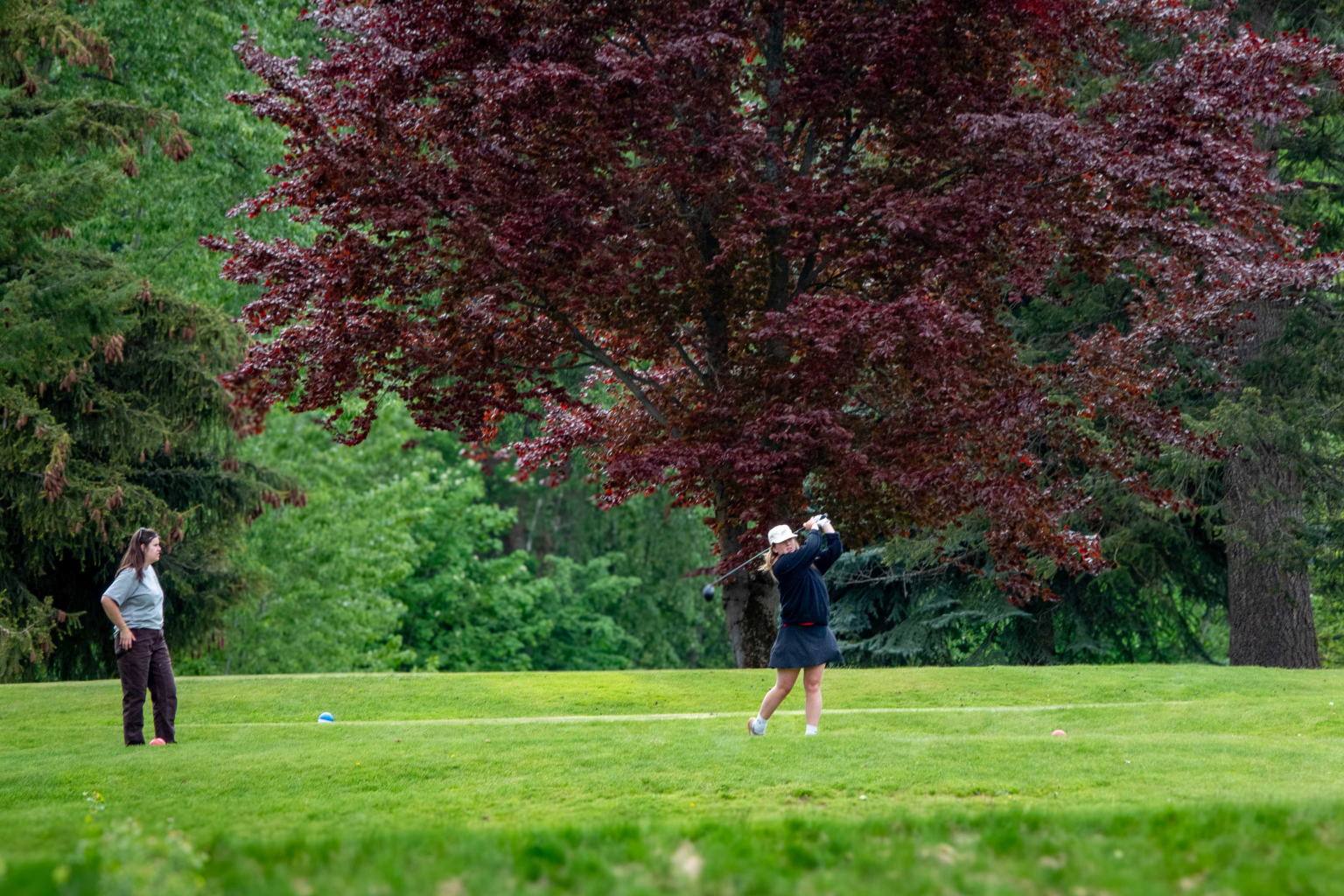Hole6May2026Grace Golfer using a driver on a scenic mountain golf hole